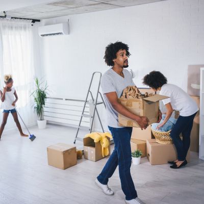 movers lifting boxes and cleaning inside a house